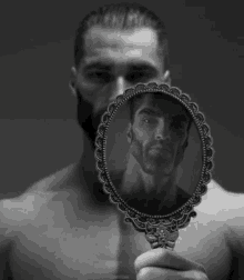 a man without a shirt is looking at his reflection in a small mirror