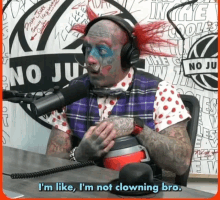 a tattooed man wearing headphones and a top hat says i 'm like i 'm not clowning bro