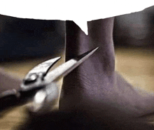 a person is cutting their ankle with scissors with a speech bubble above them