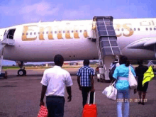 a group of people are walking towards a plane that says emirates