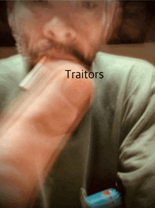 a blurred image of a man with the word traitors written on it