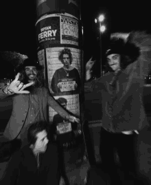 a black and white photo of people posing in front of a poster that says bryan ferry