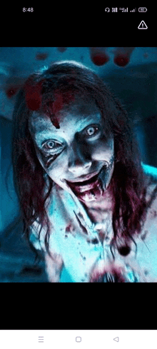 a close up of a scary zombie with blood on her face .