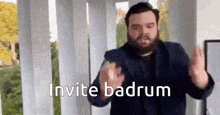 a man with a beard is making a funny face and says invite badrum .