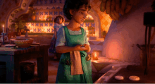 a girl in a green apron is smiling in a room with candles