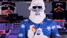 a man wearing a blue sweater with snowflakes on it stands in front of a monitor that says ' double ' on it