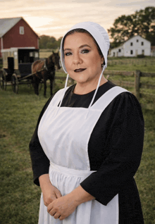 a woman in a black dress and white apron is standing in a field with a horse drawn carriage in the background