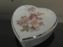 a white heart shaped box with flowers on it