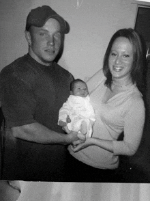 a man and a woman holding a baby in their arms