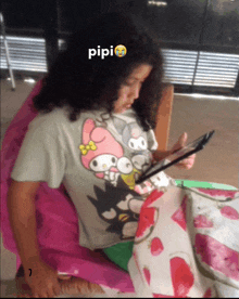 a girl wearing a t-shirt with my melody on it is using a tablet