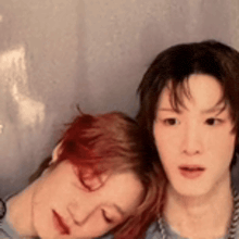 a man and a woman are laying next to each other with their heads on each other .