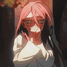 a girl with pink hair and yellow eyes covering her face with her hands