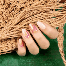 a close up of a woman 's nails with a crocheted bag in the background