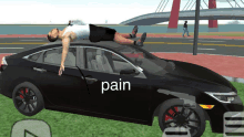 a man is laying on top of a car with the word pain written on the side