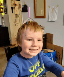 a young boy wearing a blue shirt that says off fox