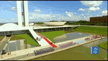 an aerial view of a building with a red carpet in front of it and a blue arrow pointing to the left