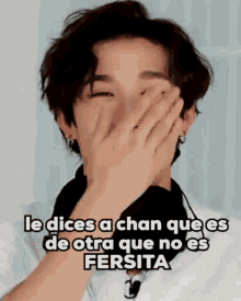 a young man is covering his face with his hands and a caption in spanish .