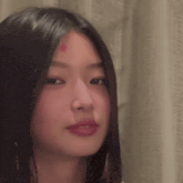 a close up of a woman 's face with long black hair and red lipstick