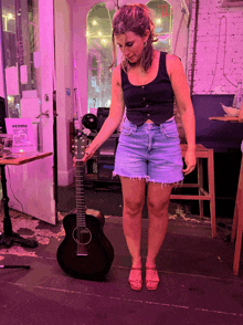 a woman is holding a guitar in front of a sign that says venmo