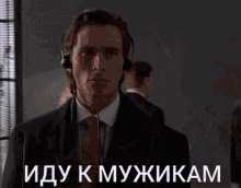 a man in a suit and tie is wearing headphones and says иду к мужчинам in russian