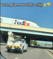a truck is driving under a bridge with a fedex plane behind it
