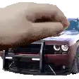a hand is reaching out towards a car with a bumper protector on it .