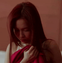 a woman with her eyes closed is wearing a red dress