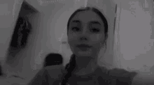 a woman is taking a selfie in a black and white photo .