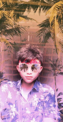 a young man wearing sunglasses and a bandana with palm trees reflected in them