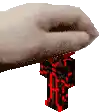 a person 's hand is holding a red and black block .