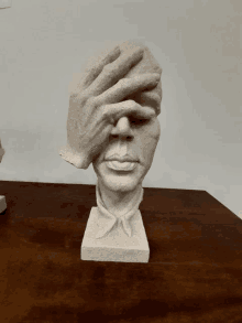 a statue of a hand covering a man 's eyes