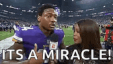 a football player is talking into a microphone while a woman looks on .