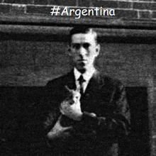 a black and white photo of a man holding a cat with argentina written on the bottom