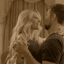 a man and a woman are dancing together in a room in a sepia tone .