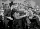 a man and a woman are dancing in front of a crowd with kc written on the bottom right