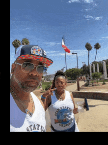 a man and a woman are posing for a picture and the man is wearing a tank top that says " star status cruises "