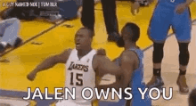 a basketball player is hugging another player on the court while another player says `` jalen owns you '' .