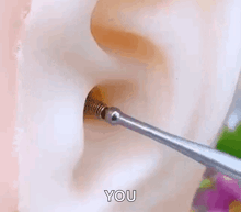 a close up of a person 's ear with a screw in it and the words `` you '' written on it .