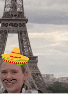 a man wearing a sombrero and a fake mustache in front of the eiffel tower