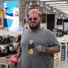 a man with pink hair is wearing sunglasses and a polo bear t-shirt .