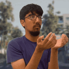 a man wearing glasses and a purple shirt is clapping