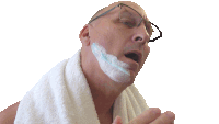 a man with a towel around his neck shaves his face