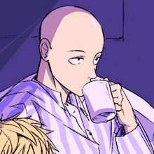 a bald man is drinking a cup of coffee while sitting on a couch .