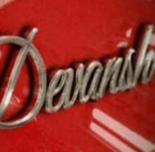 a close up of a red car with the word devanish on it .