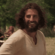 a man with long hair and a beard wearing a white shirt