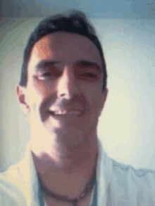 a man wearing a white shirt is smiling for the camera