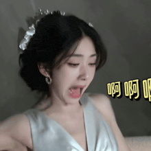a woman in a white dress with a flower in her hair is making a funny face