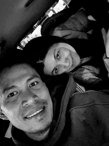 a black and white photo of a man and a woman in a car