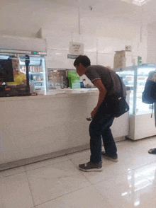 a man standing in front of a counter that has a sign that says order & pay