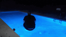 a man is diving into a pool at night